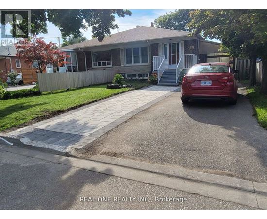 A red car is parked in front of a house with a sign that says "REAL ONE REALTY INC Brokerage.".