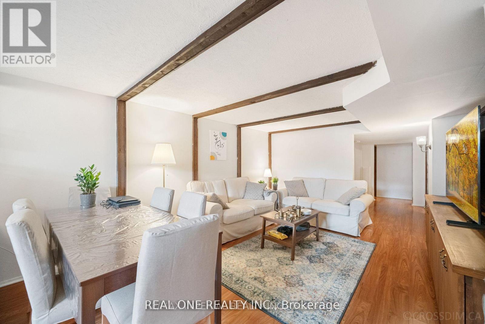 A well-lit, modern living room with a dining table and white furniture.