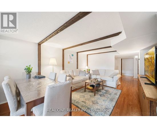 A well-lit, modern living room with a dining table and white furniture.