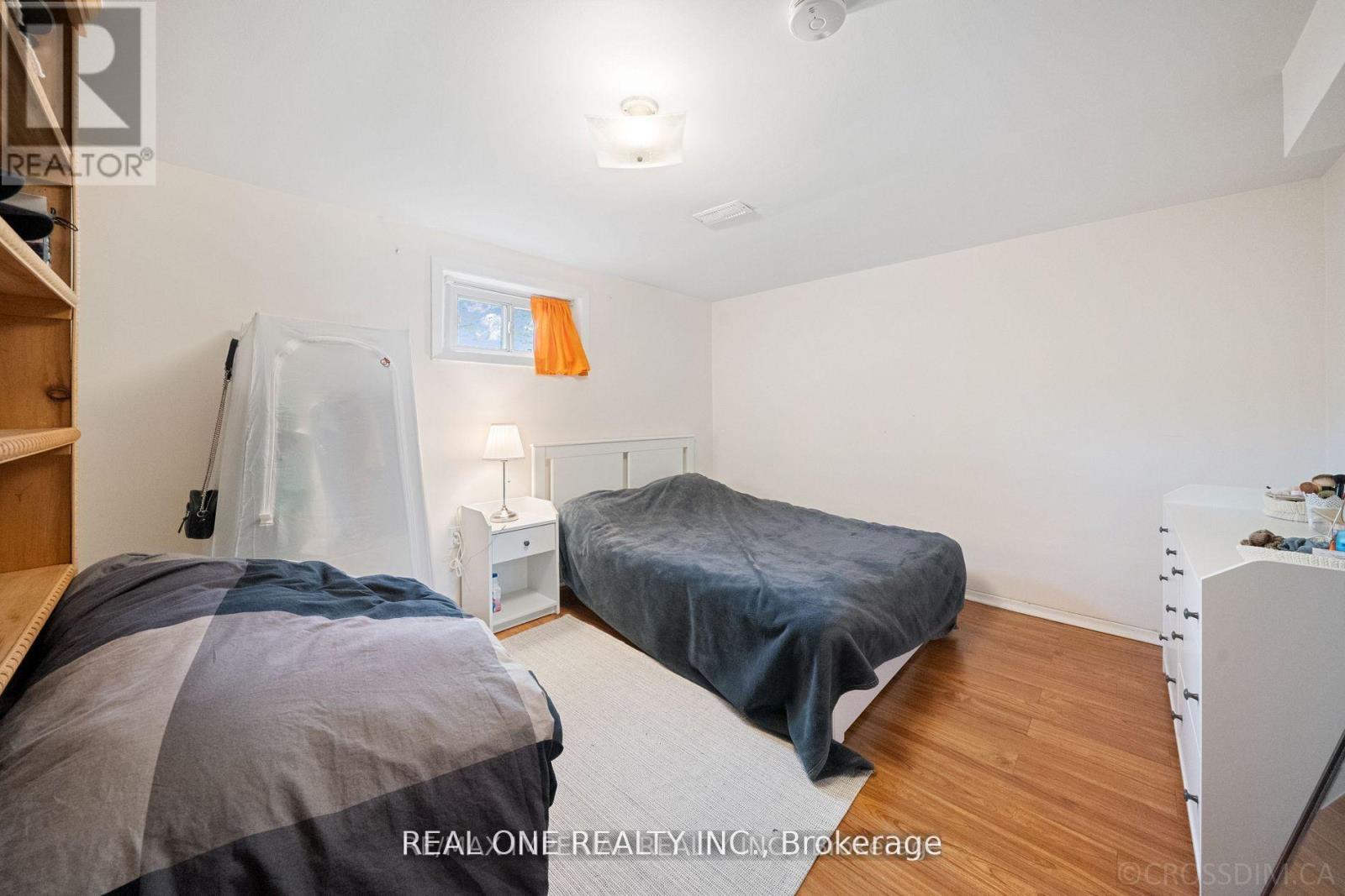 A bedroom with two beds and a dresser.
