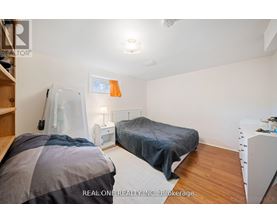 A bedroom with two beds and a dresser.