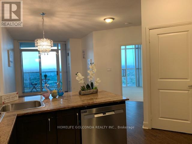 A kitchen with a sink, a window, and a chandelier.