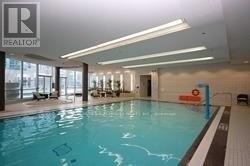 A large indoor swimming pool with a Realtor sign in the background.