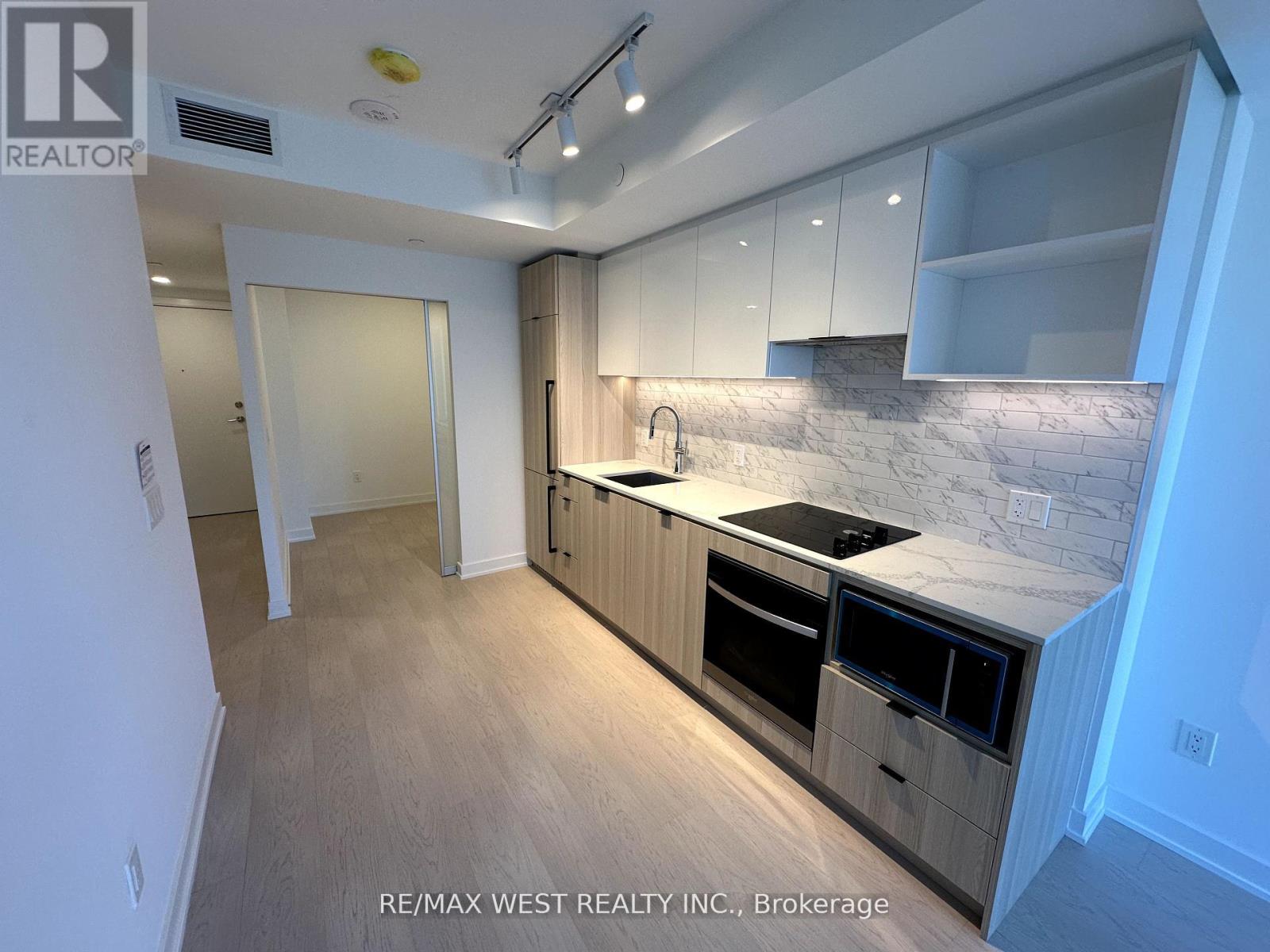 A kitchen with a marble countertop and wooden cabinets.