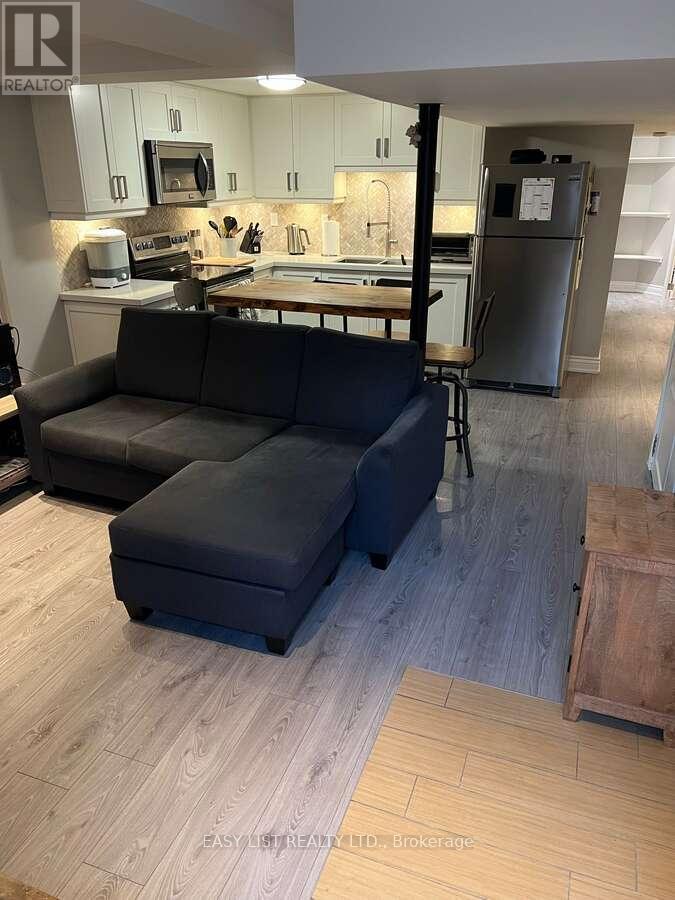 A kitchen with a black couch and a wooden table.