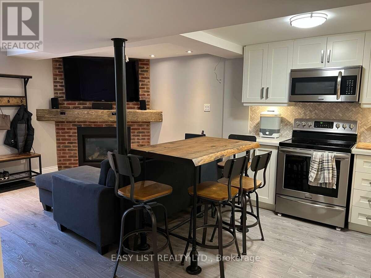 A modern kitchen with a brick fireplace and stainless steel appliances.