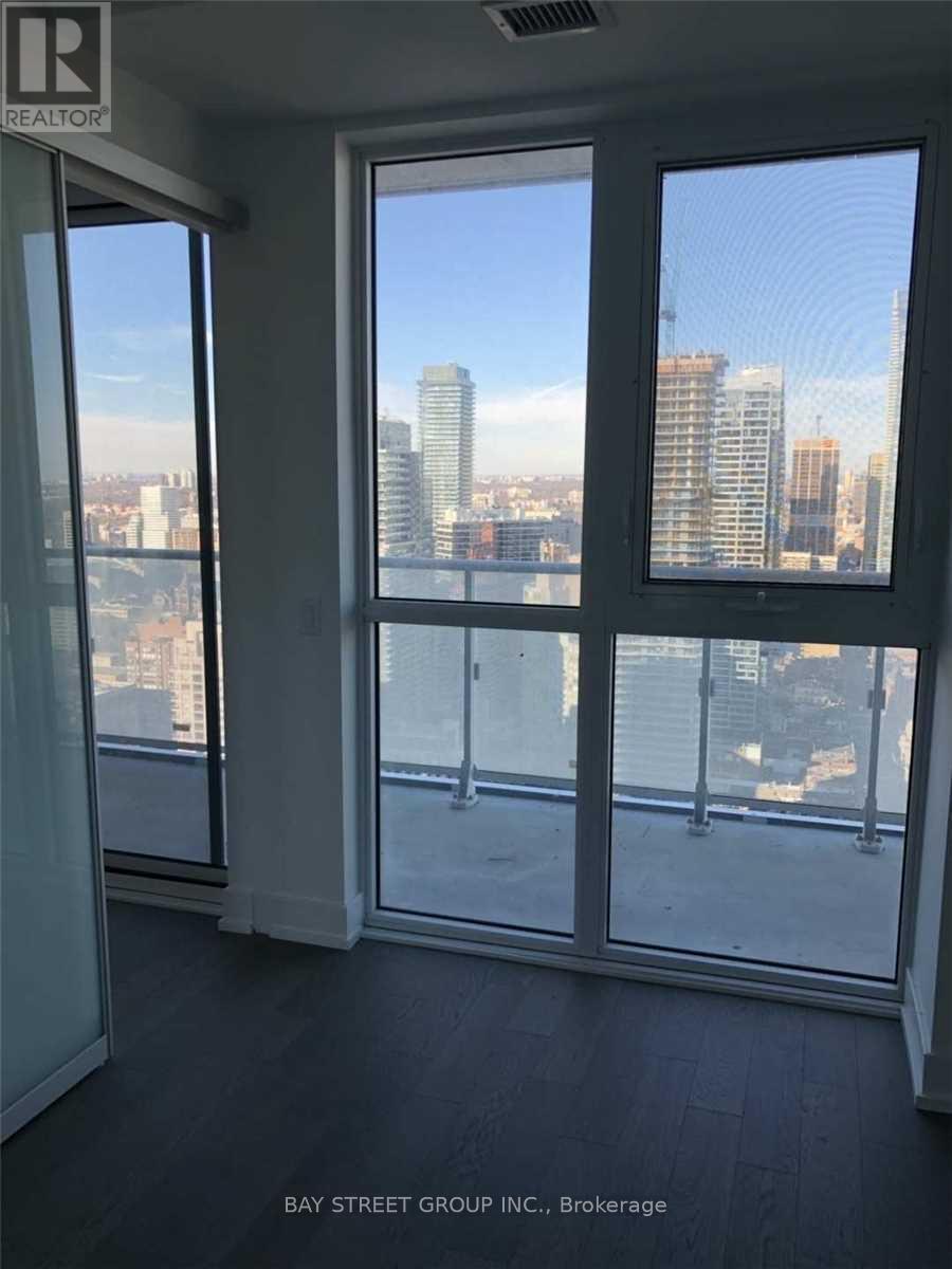 A room with a view of the cityscape through large windows.