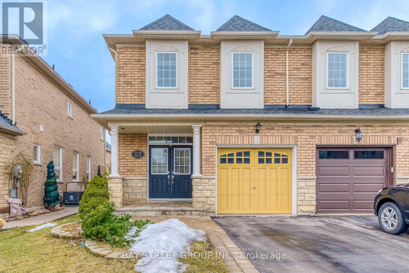 A house with a yellow garage door is for sale.