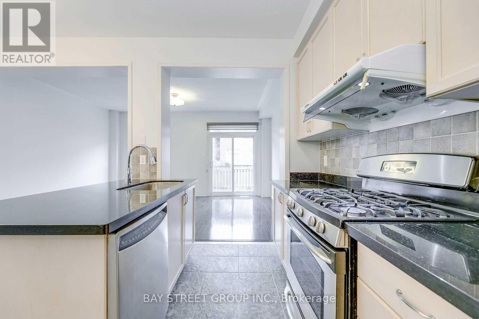 A kitchen with a stove top oven and a refrigerator.