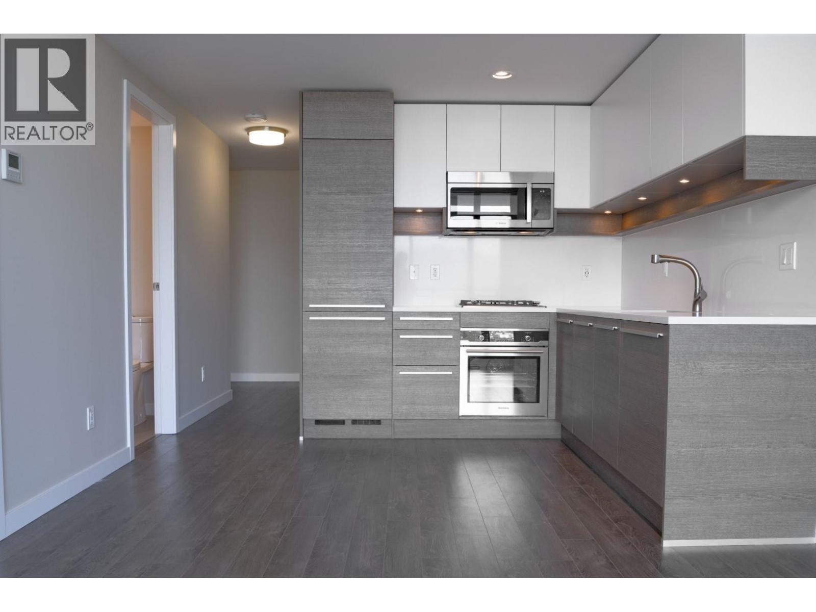 A modern kitchen with a stainless steel oven and a microwave above it.