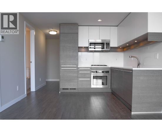 A modern kitchen with a stainless steel oven and a microwave above it.