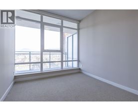 A room with a large window and a carpeted floor.