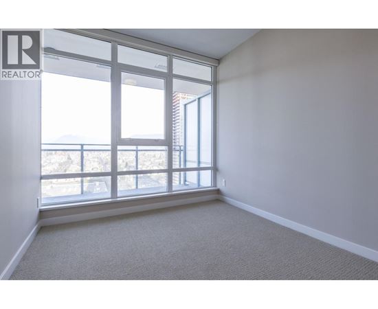 A room with a large window and a carpeted floor.