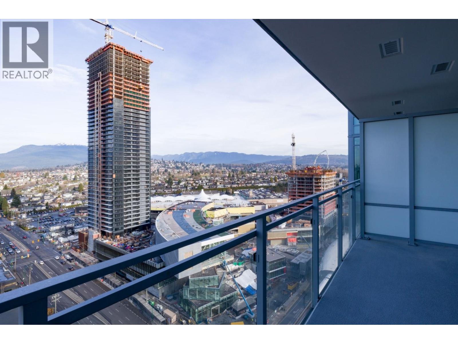 A view from a balcony overlooking a construction site with a crane and a building under construction.