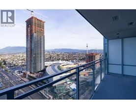 A view from a balcony overlooking a construction site with a crane and a building under construction.