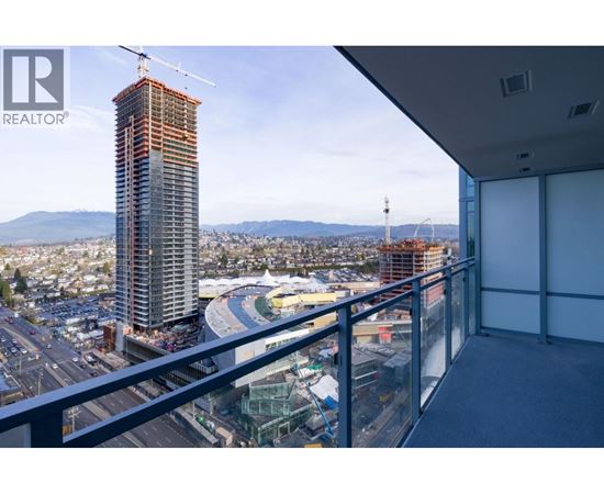 A view from a balcony overlooking a construction site with a crane and a building under construction.