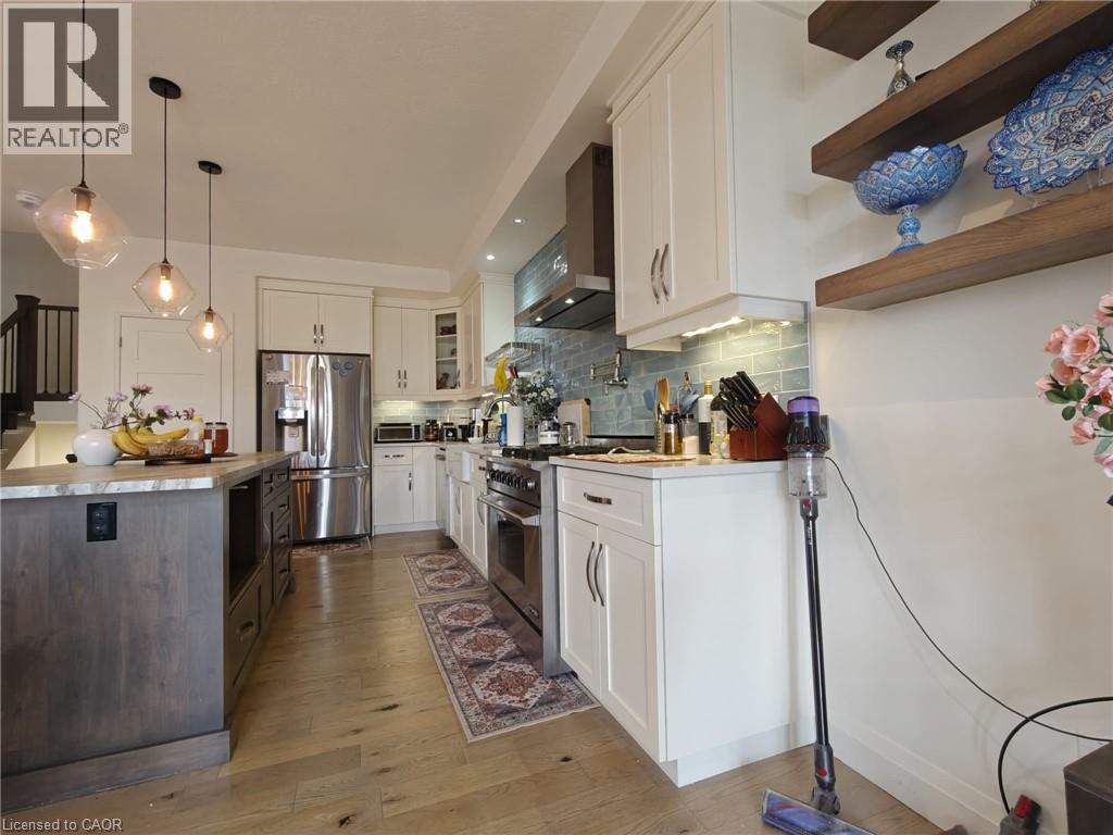 A modern kitchen with white cabinets and a wooden floor.