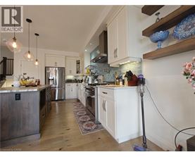 A modern kitchen with white cabinets and a wooden floor.