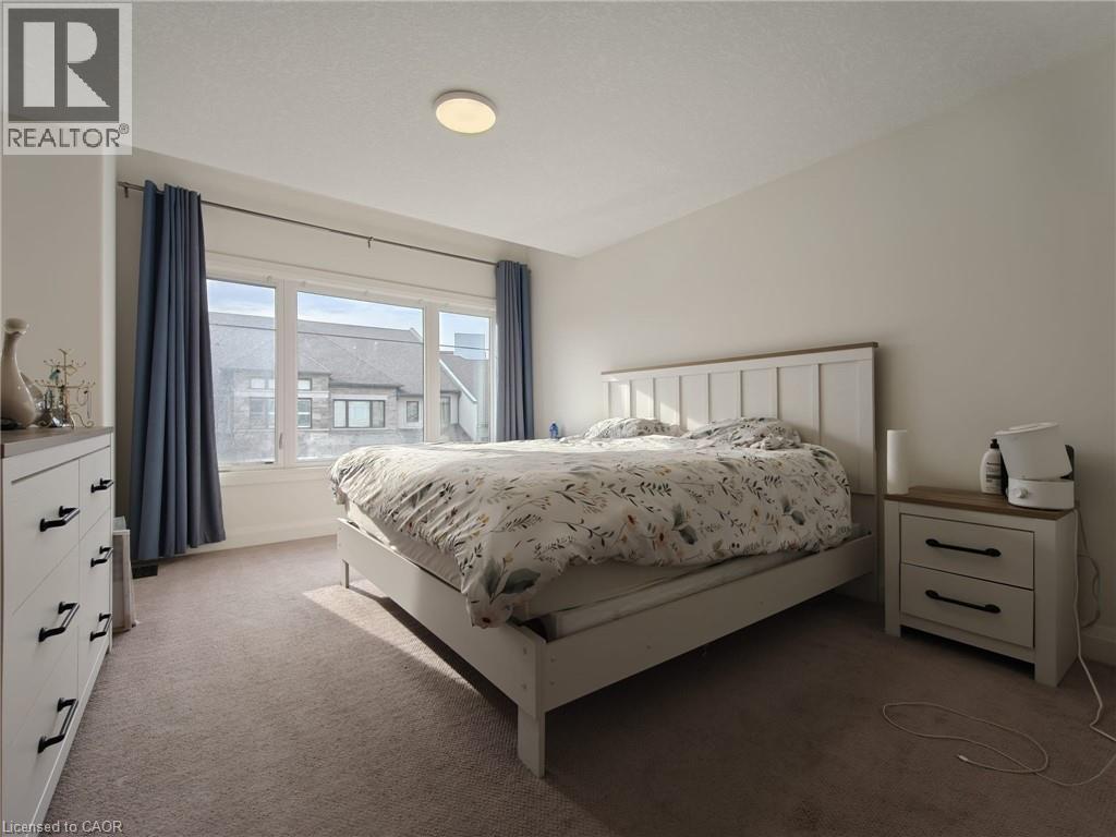 A bedroom with a bed, nightstand, and window.