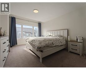 A bedroom with a bed, nightstand, and window.