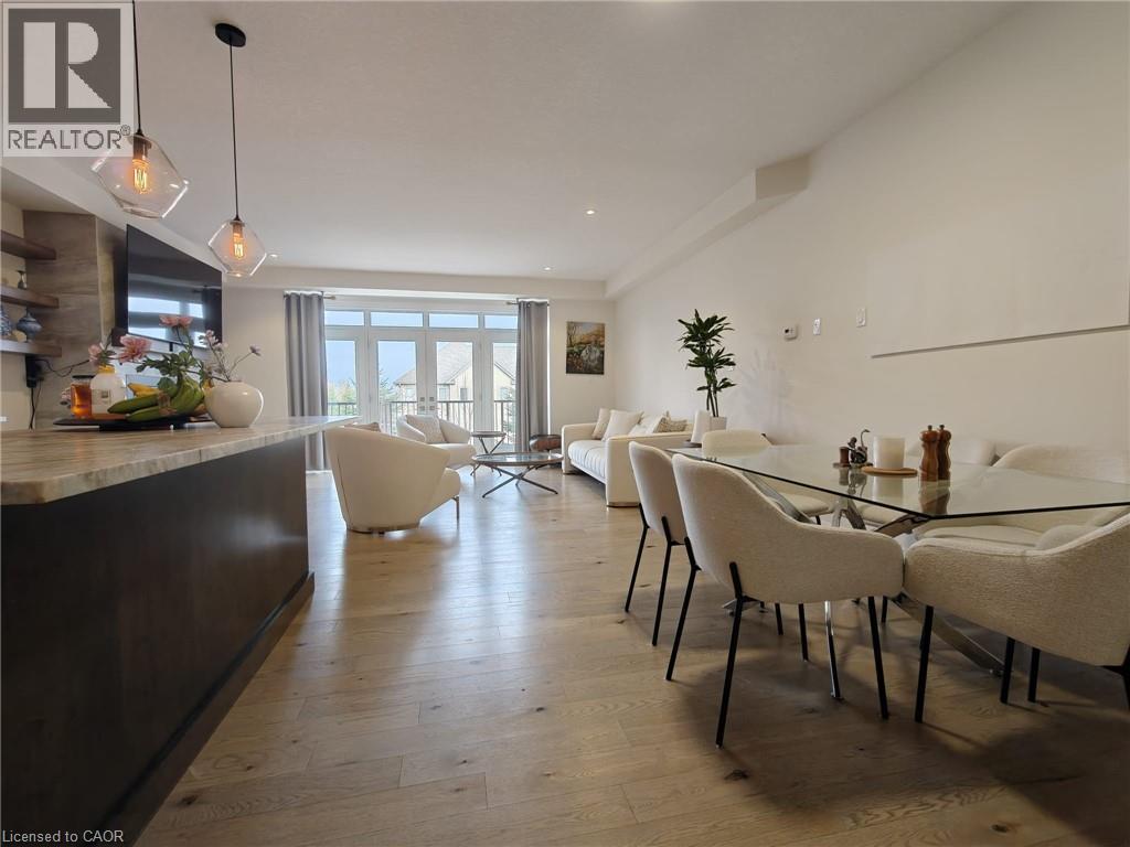 A modern dining room with a glass table and white chairs.