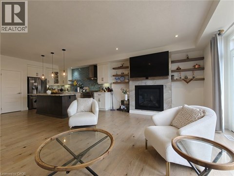 A modern living room with a glass table and white chairs.