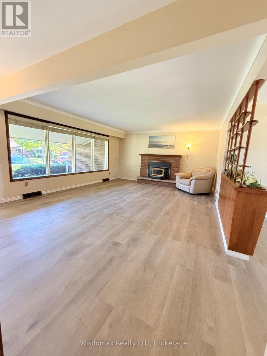 A spacious living room with a fireplace and a large window.