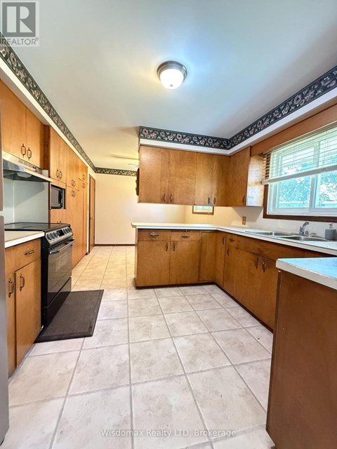 A kitchen with wooden cabinets and a tiled floor.
