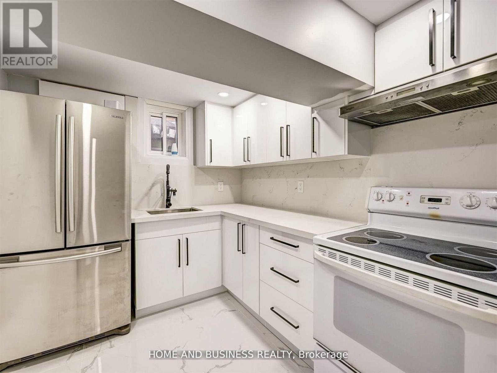 A modern kitchen with stainless steel appliances and white cabinets.