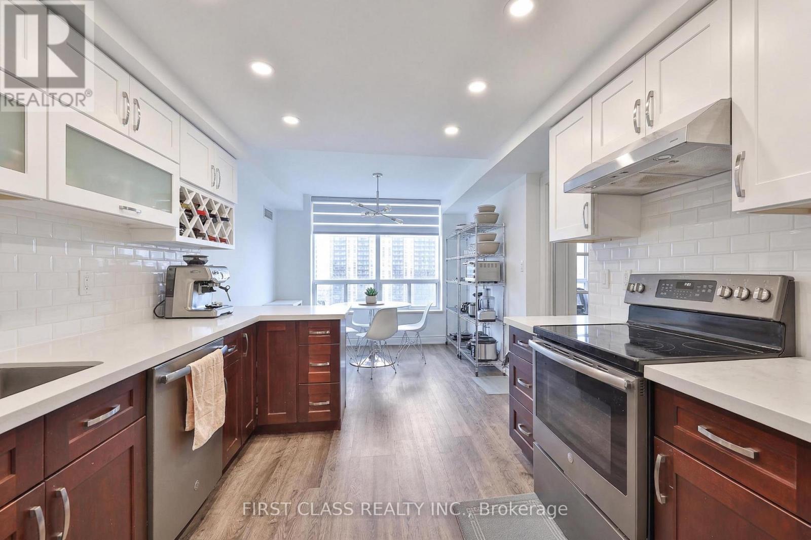 A modern kitchen with dark wood cabinets and stainless steel appliances.