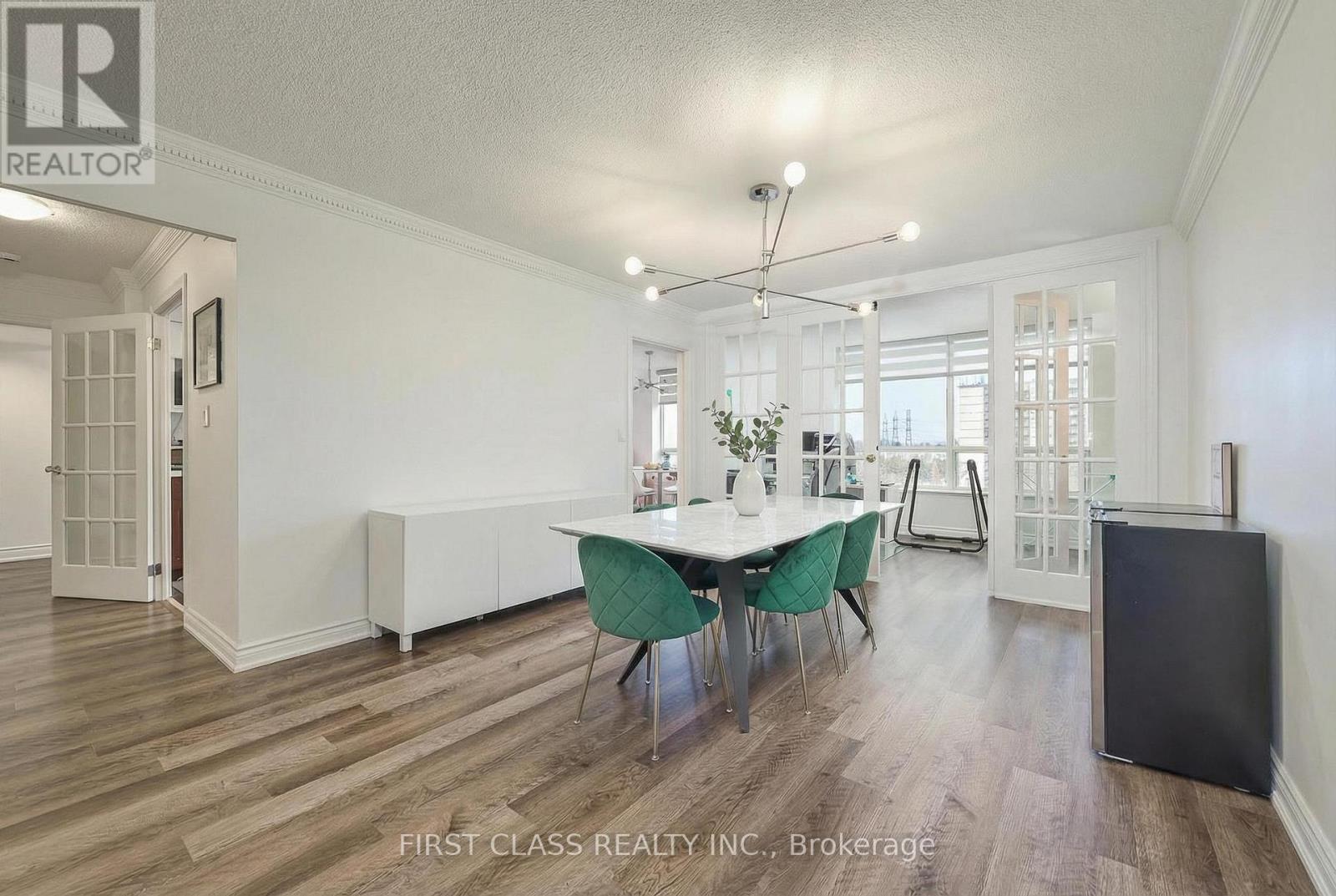 A dining room with a white table and green chairs.