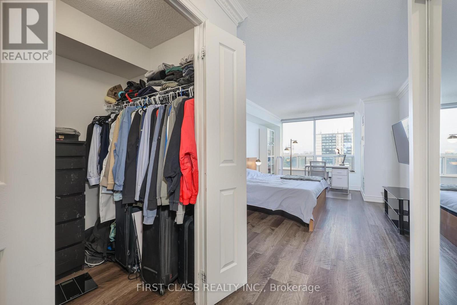 A bedroom with a large closet and a bed in the background.