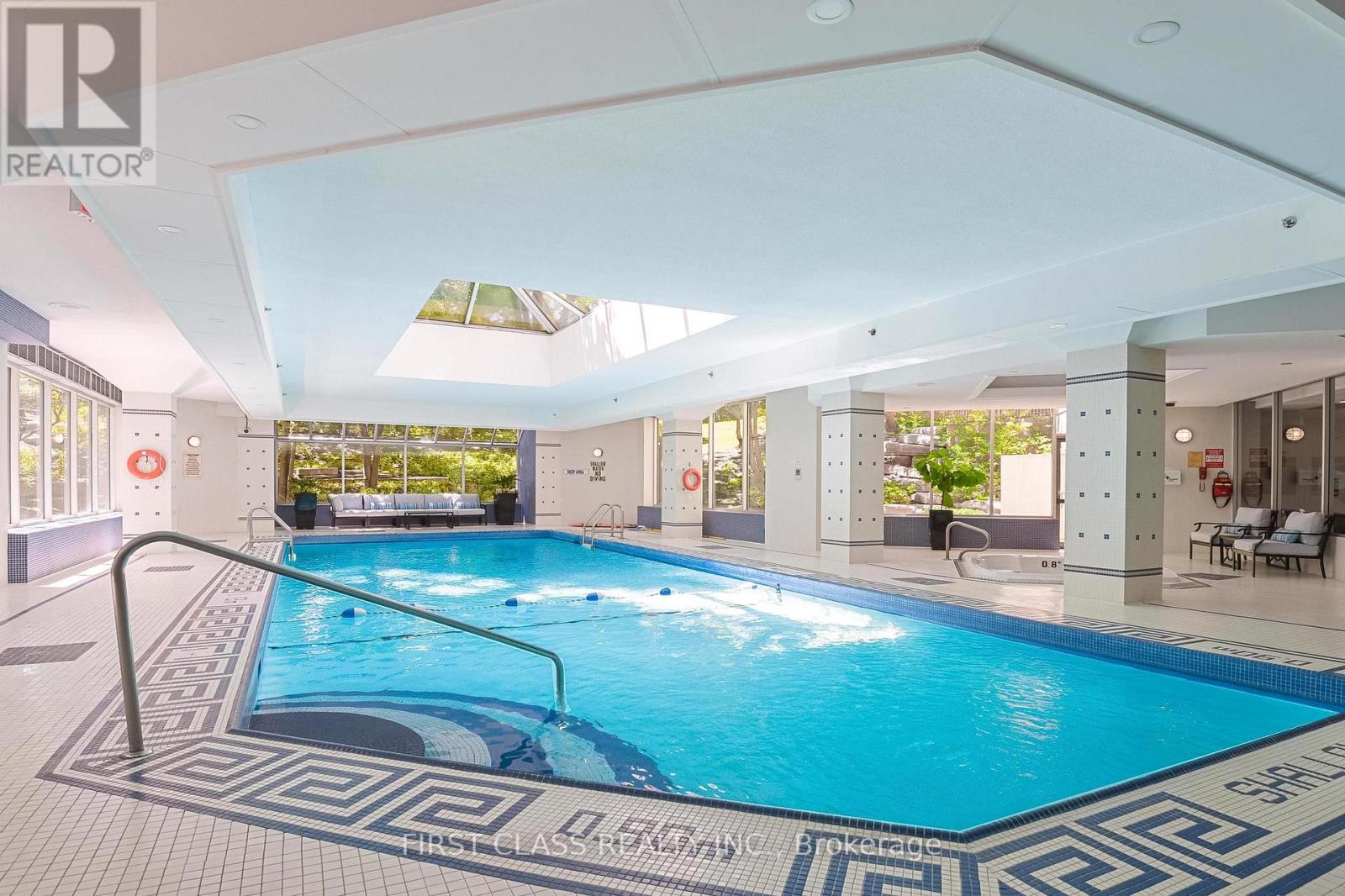 A swimming pool inside a building with a tiled floor.