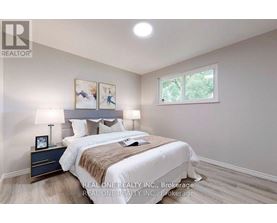 A bedroom with a bed, nightstand, and lamp.