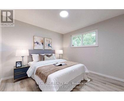 A bedroom with a bed, nightstand, and lamp.