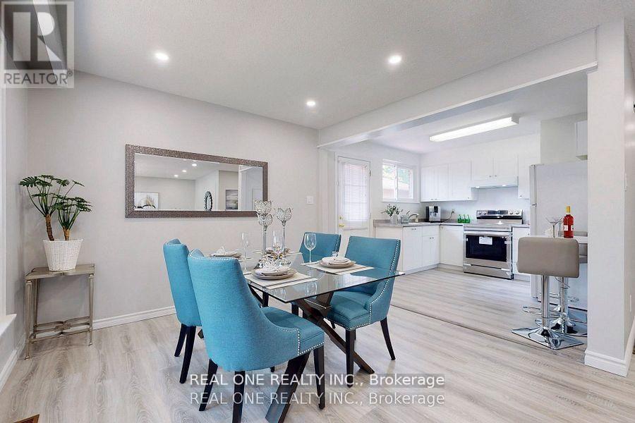 A dining room with a table set for two and a kitchen in the background.