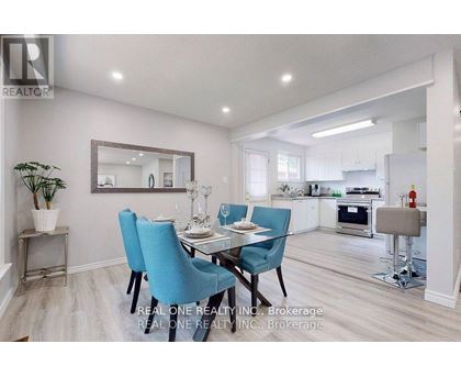 A dining room with a table set for two and a kitchen in the background.