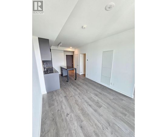 A spacious room with a grey floor and white walls.
