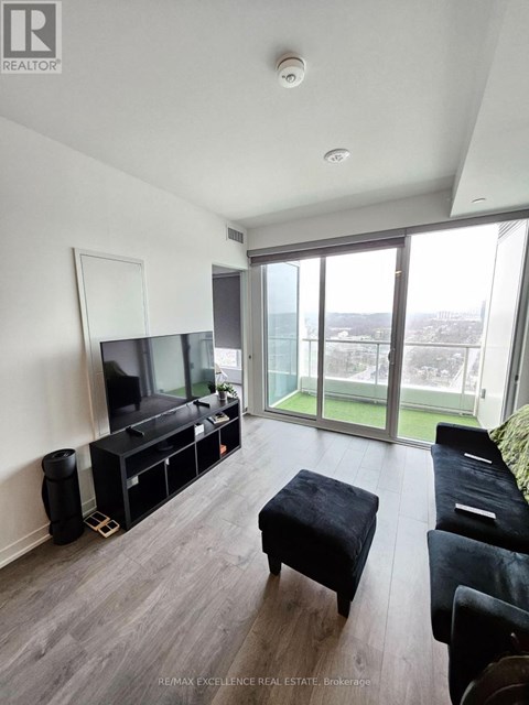 A living room with a television and a glass door.