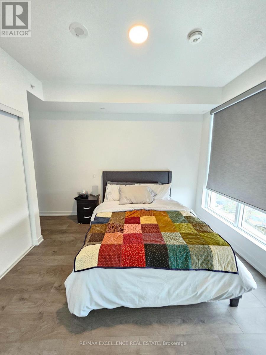 A bedroom with a bed, nightstand, and window.