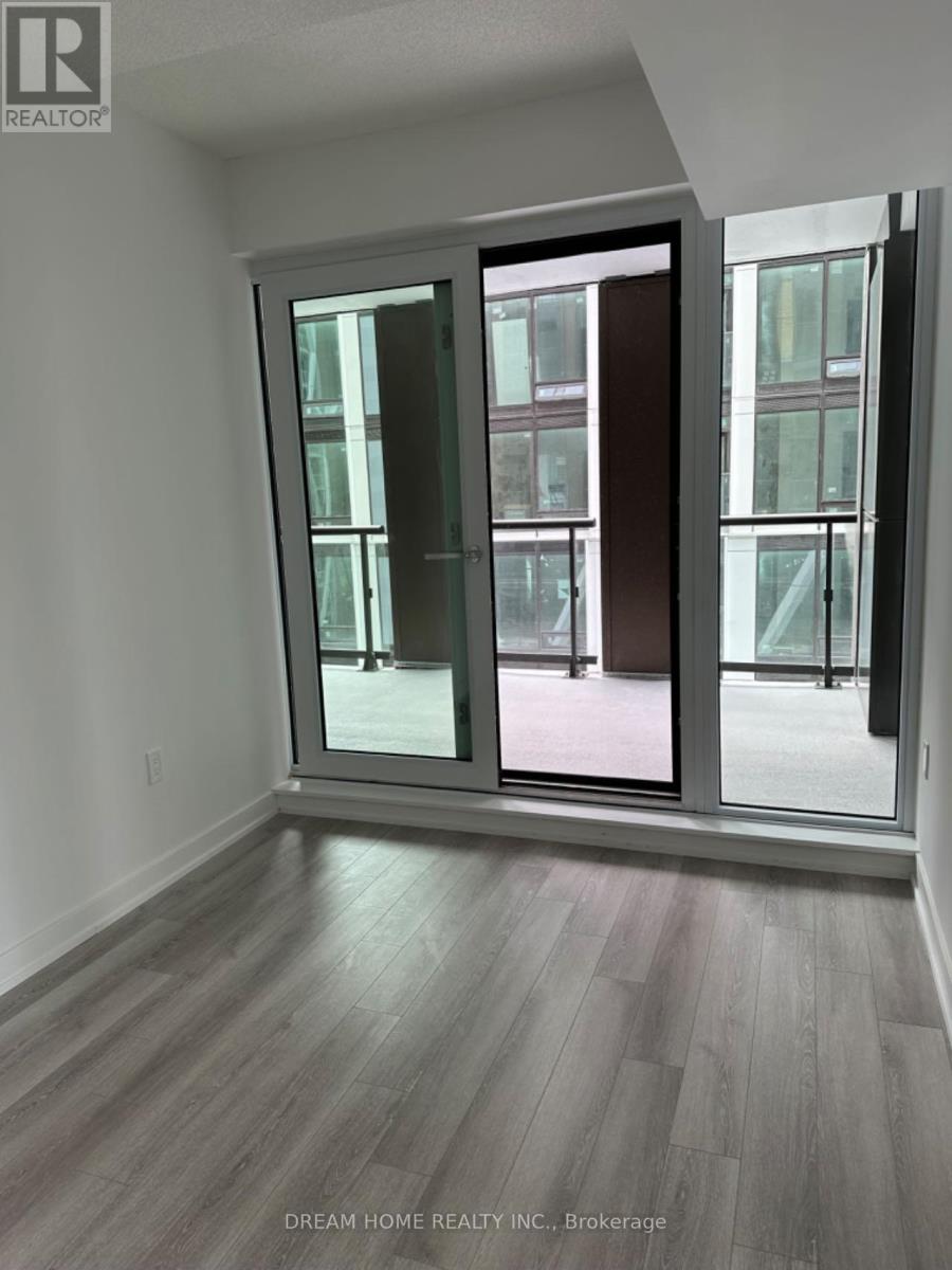 A room with a large window and a wooden floor.