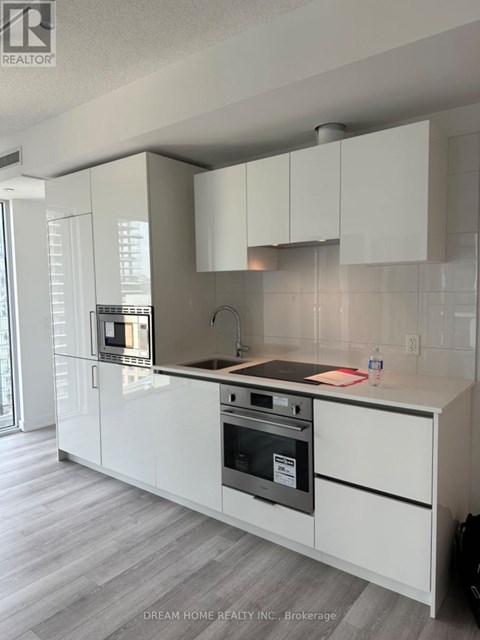 A modern kitchen with white cabinets and a stainless steel oven.