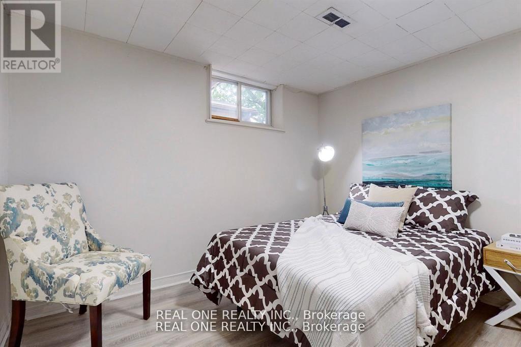 A bedroom with a bed, chair, and painting on the wall.