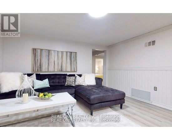 A living room with a grey couch and a white coffee table.