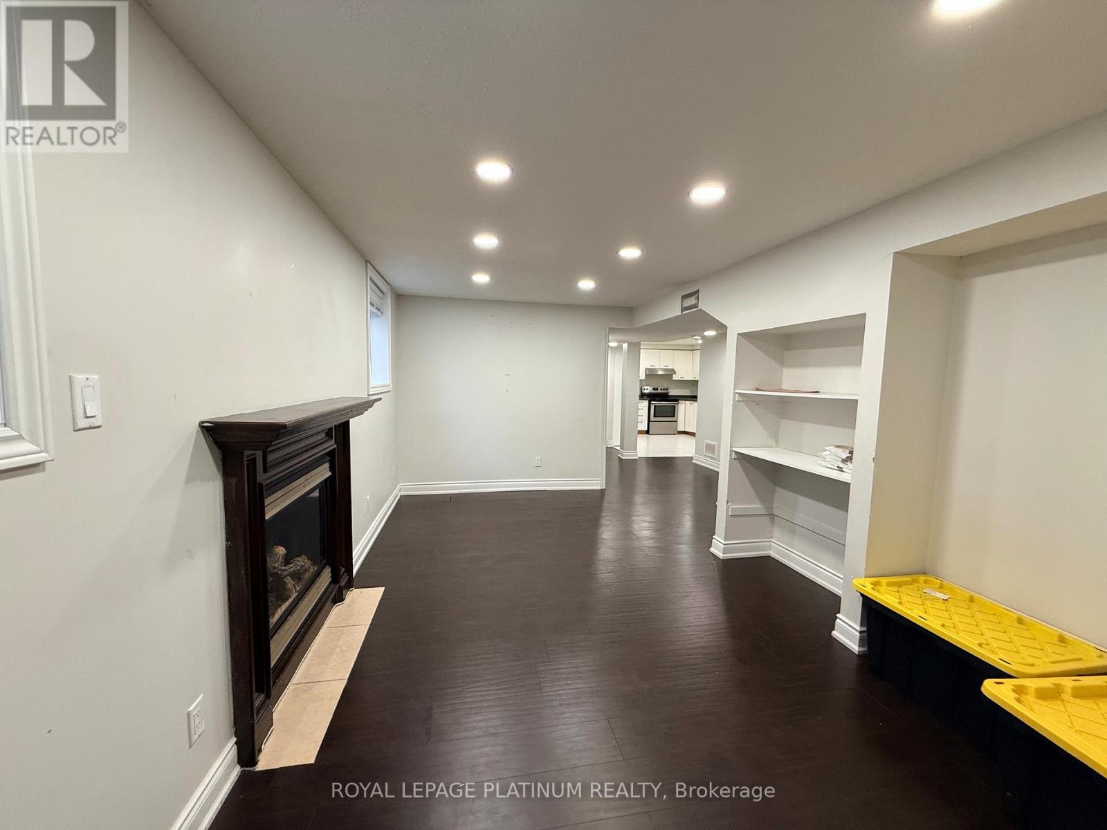 A room with a fireplace and shelves.