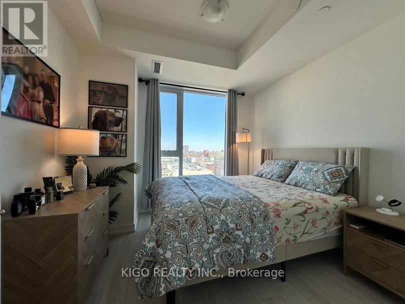 A bedroom with a large bed and a view of the city through the window.