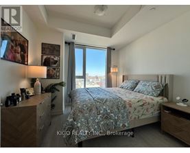 A bedroom with a large bed and a view of the city through the window.