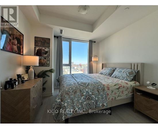 A bedroom with a large bed and a view of the city through the window.