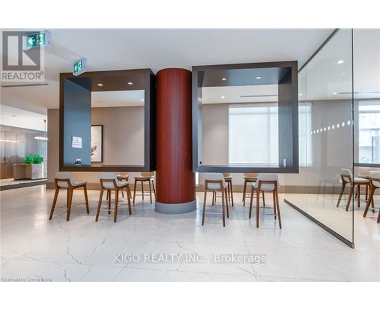 A modern office space with a glass wall and wooden chairs.