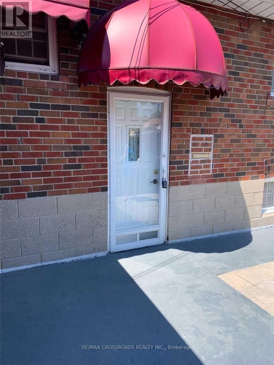 A white door is under a red awning.